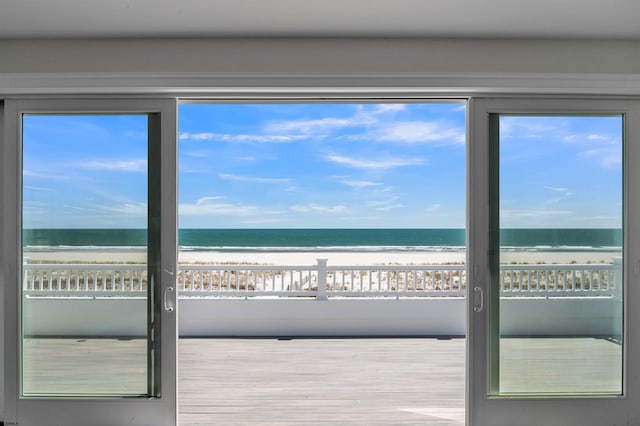 doorway to outside featuring a beach view and a water view