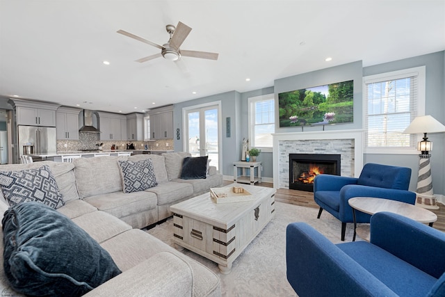 living room with light wood-style floors, recessed lighting, plenty of natural light, and baseboards