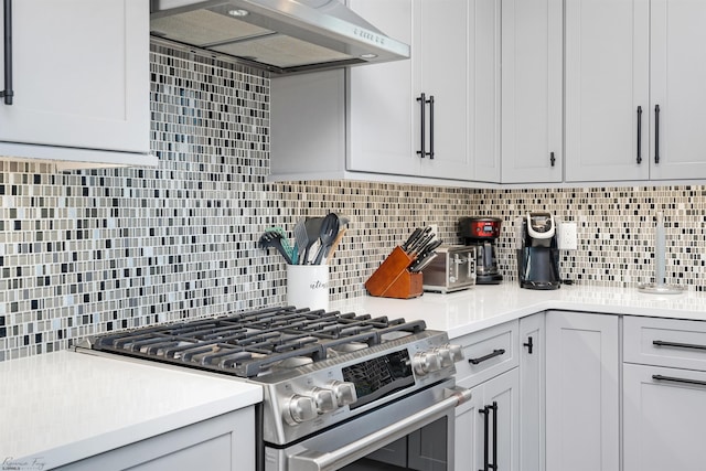 kitchen featuring light countertops, stainless steel gas stove, backsplash, and extractor fan