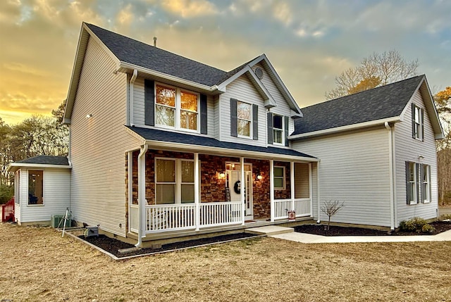 traditional home with a shingled roof and covered porch