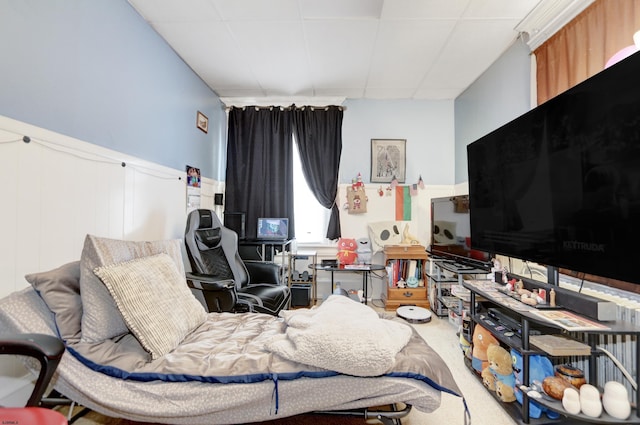 bedroom featuring a paneled ceiling, a wainscoted wall, and carpet