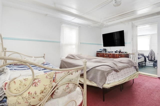 carpeted bedroom featuring a wainscoted wall