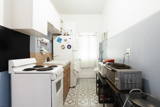 kitchen featuring white electric stove, light countertops, stainless steel microwave, and a sink