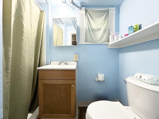 full bath featuring toilet, a shower with shower curtain, and vanity