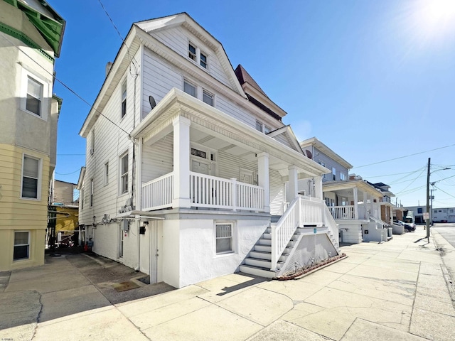 view of front of home featuring stairway and a porch