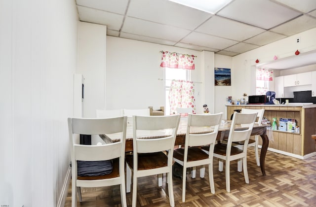 dining room with a paneled ceiling and a wealth of natural light