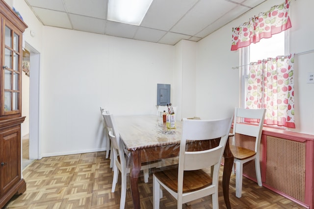 dining room with a drop ceiling and baseboards