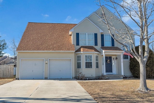 traditional-style house featuring an attached garage, driveway, fence, and a shingled roof