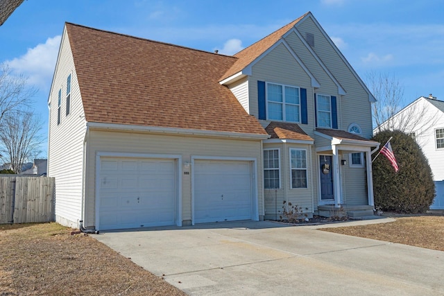 traditional home with a shingled roof, concrete driveway, fence, and a garage