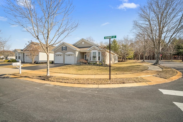 view of front of house with a front yard, driveway, and an attached garage