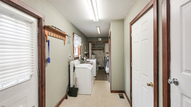 clothes washing area featuring laundry area, separate washer and dryer, visible vents, and baseboards