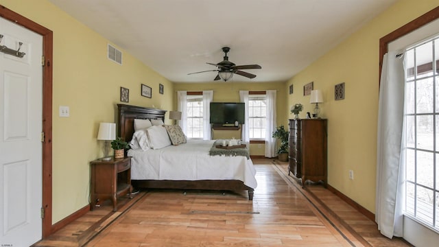 bedroom featuring baseboards, ceiling fan, visible vents, and light wood-style floors