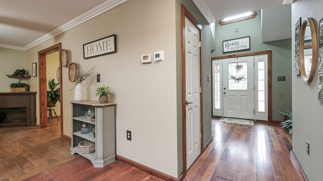 foyer entrance featuring wood-type flooring, a fireplace, crown molding, and baseboards