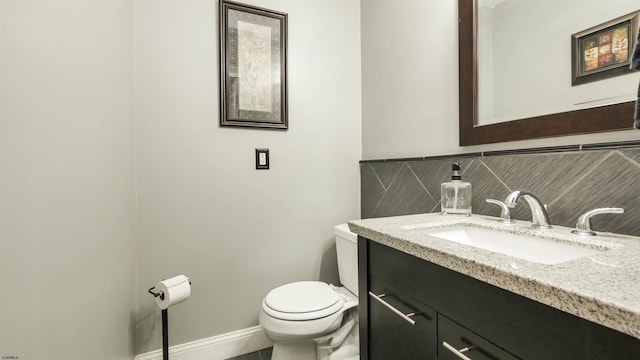 bathroom with toilet, baseboards, backsplash, and vanity