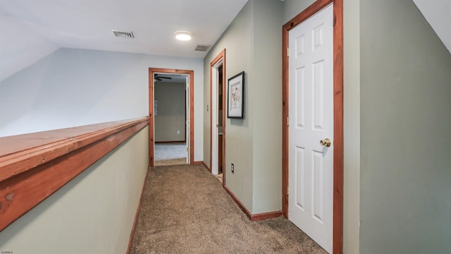 corridor featuring light carpet, visible vents, and baseboards