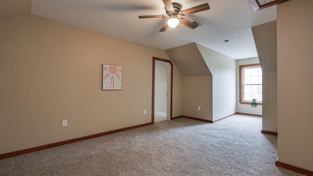 additional living space featuring carpet floors, ceiling fan, baseboards, and vaulted ceiling