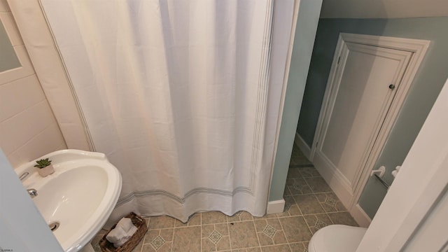 bathroom with tile patterned flooring, toilet, a sink, and a shower with curtain