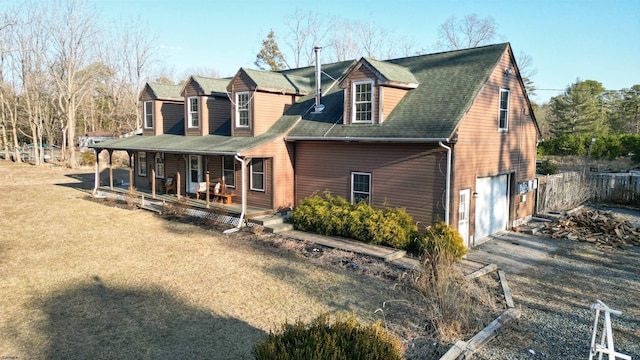 view of front facade featuring a porch, an attached garage, fence, roof with shingles, and a front lawn