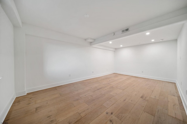 spare room featuring light wood-style flooring, visible vents, baseboards, and recessed lighting