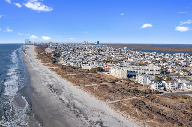 drone / aerial view with a water view, a beach view, and a city view