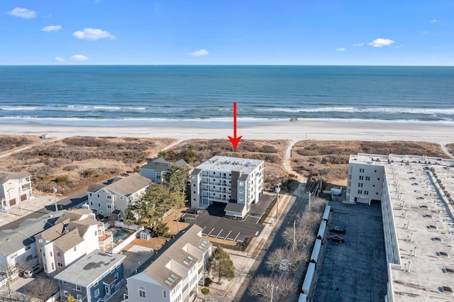 birds eye view of property featuring a water view and a beach view