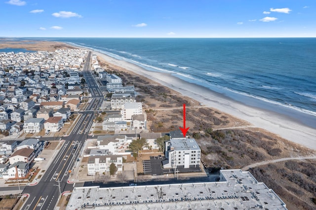 birds eye view of property featuring a water view and a beach view