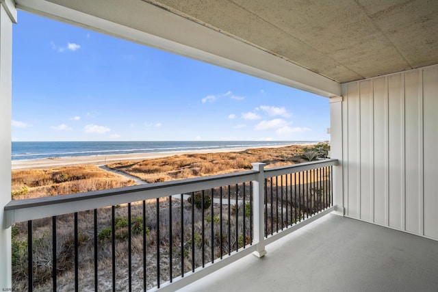 balcony featuring a view of the beach and a water view