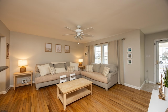 living area featuring light wood-type flooring, plenty of natural light, and baseboards