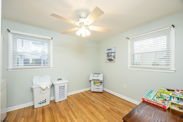 rec room with ceiling fan, wood finished floors, and baseboards