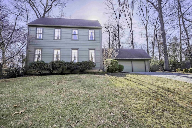 colonial inspired home with a front yard and an attached garage