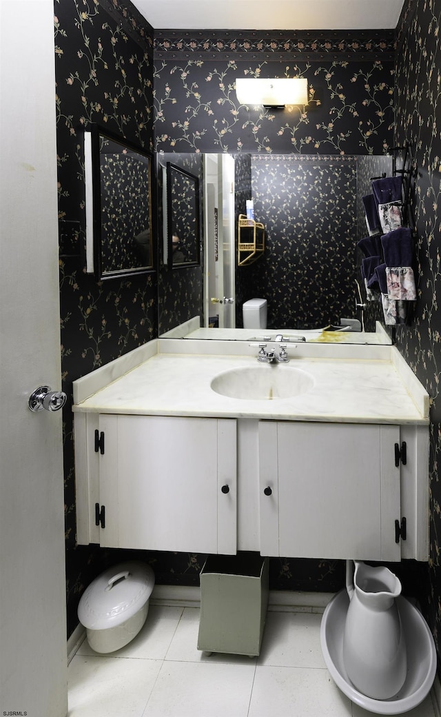 bathroom featuring tile patterned flooring, vanity, toilet, and wallpapered walls