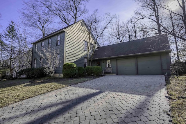 view of front of property with a garage and decorative driveway