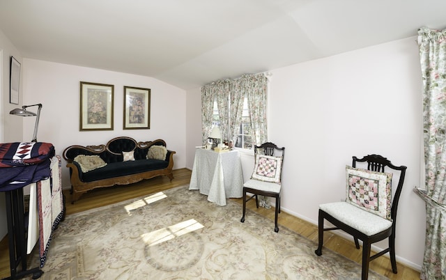 living area with lofted ceiling and wood finished floors