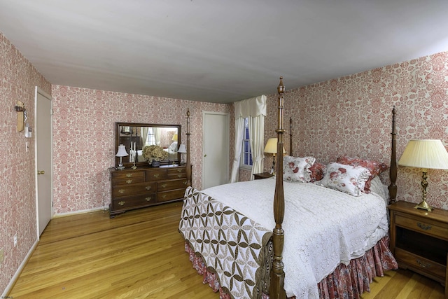 bedroom with wallpapered walls, baseboards, and wood finished floors