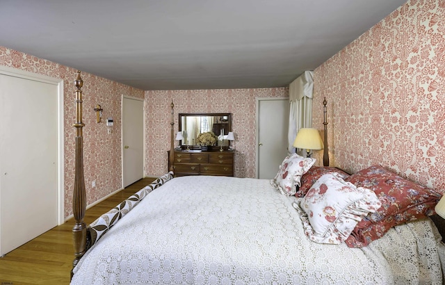 bedroom featuring wallpapered walls and wood finished floors