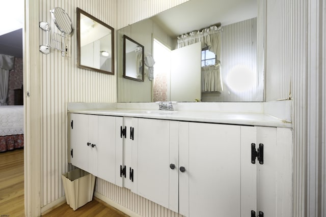 bathroom featuring vanity, ensuite bathroom, and wood finished floors