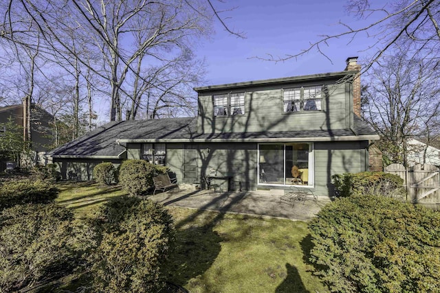 rear view of house with a chimney, fence, and a patio