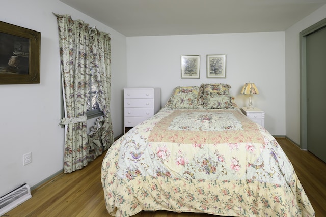 bedroom featuring baseboards, visible vents, and wood finished floors