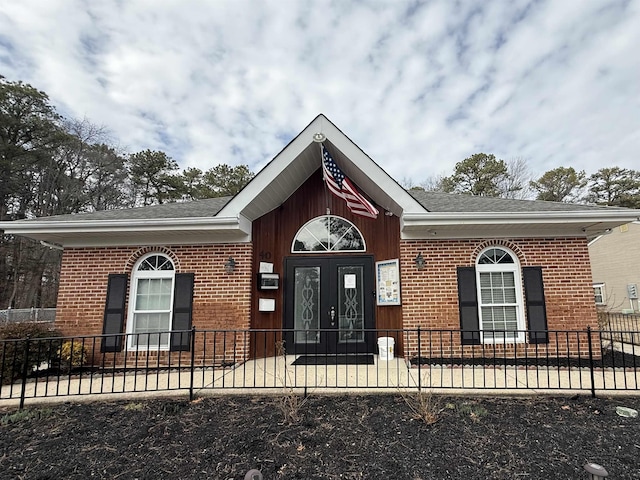 view of front of home with a fenced front yard and brick siding