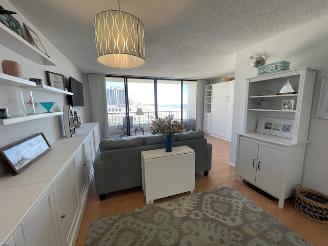 living area with a textured ceiling and a wall of windows