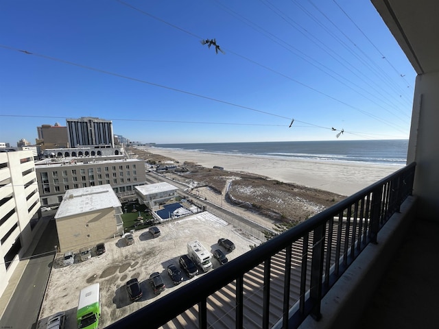 balcony featuring a view of the beach and a water view