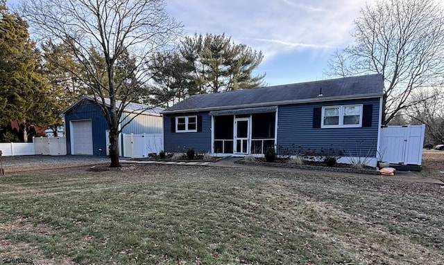 back of house with an outbuilding, a lawn, fence, and a garage