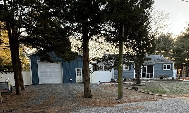 ranch-style house with driveway, a garage, fence, and an outdoor structure