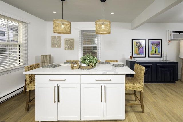 kitchen with a baseboard radiator, light wood-type flooring, a healthy amount of sunlight, and white cabinetry