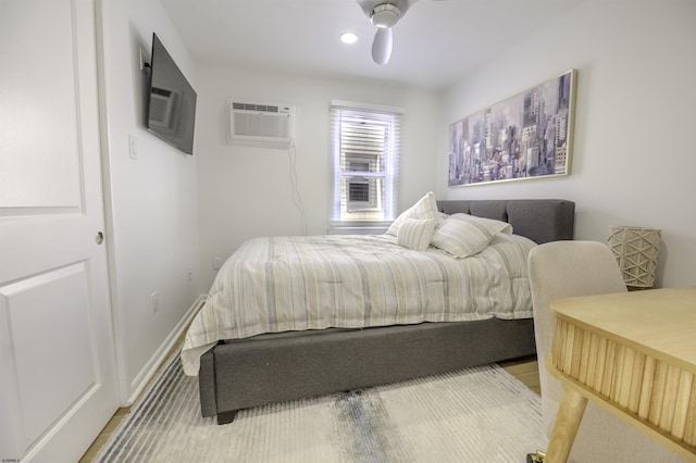 bedroom featuring ceiling fan, baseboards, an AC wall unit, and recessed lighting