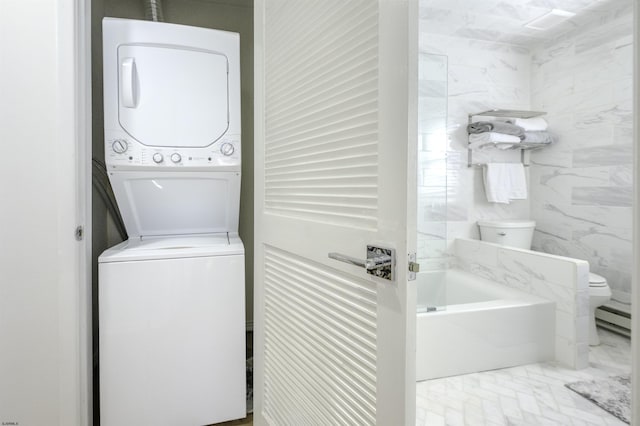 clothes washing area featuring laundry area, a baseboard radiator, tile walls, and stacked washer and clothes dryer