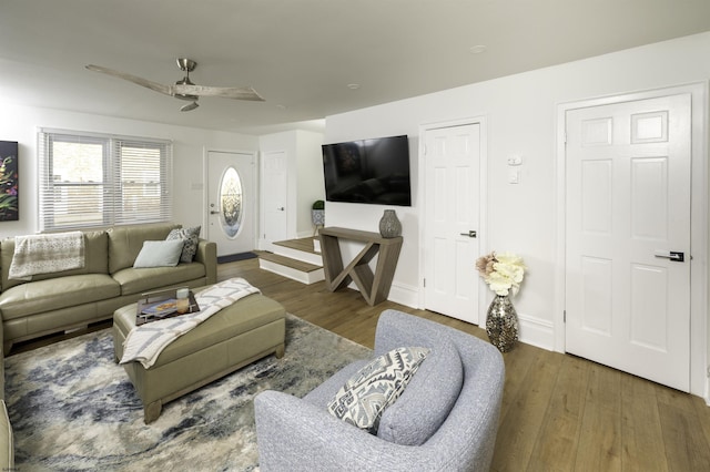 living area featuring baseboards, a ceiling fan, and wood finished floors