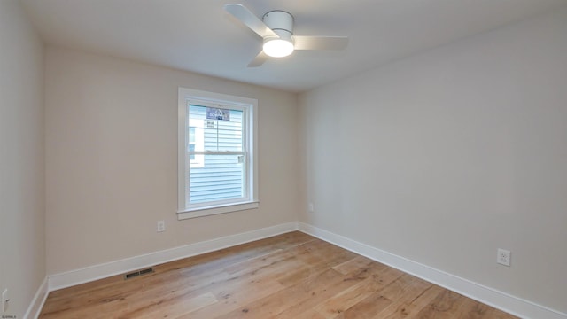 empty room featuring a ceiling fan, light wood-type flooring, visible vents, and baseboards