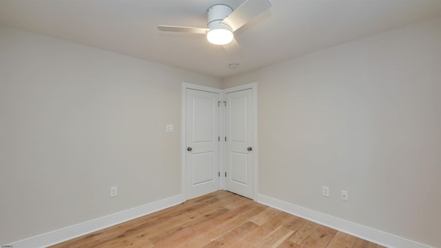 spare room with light wood-style floors, ceiling fan, and baseboards