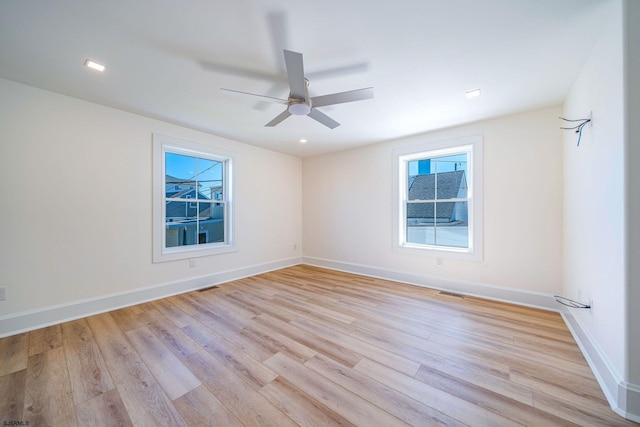 empty room with a ceiling fan, baseboards, visible vents, and light wood finished floors